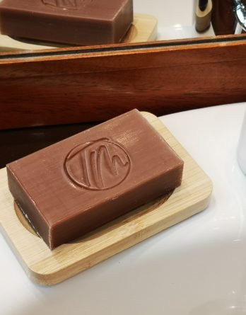 porte savon posé sur l'évier a côté du robinet de sdb avec son savon