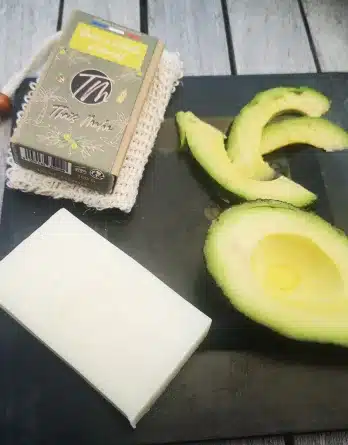 Savon à l'huile davocat peau sèche présenter dans une assiette carrée noire avec des tranches d'avocat